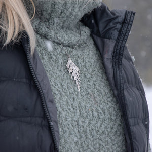 Woman wearing handmade silver cedar necklace in winter