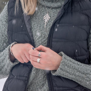 Woman wearing handmade, silver, nature inspired jewelry in winter 