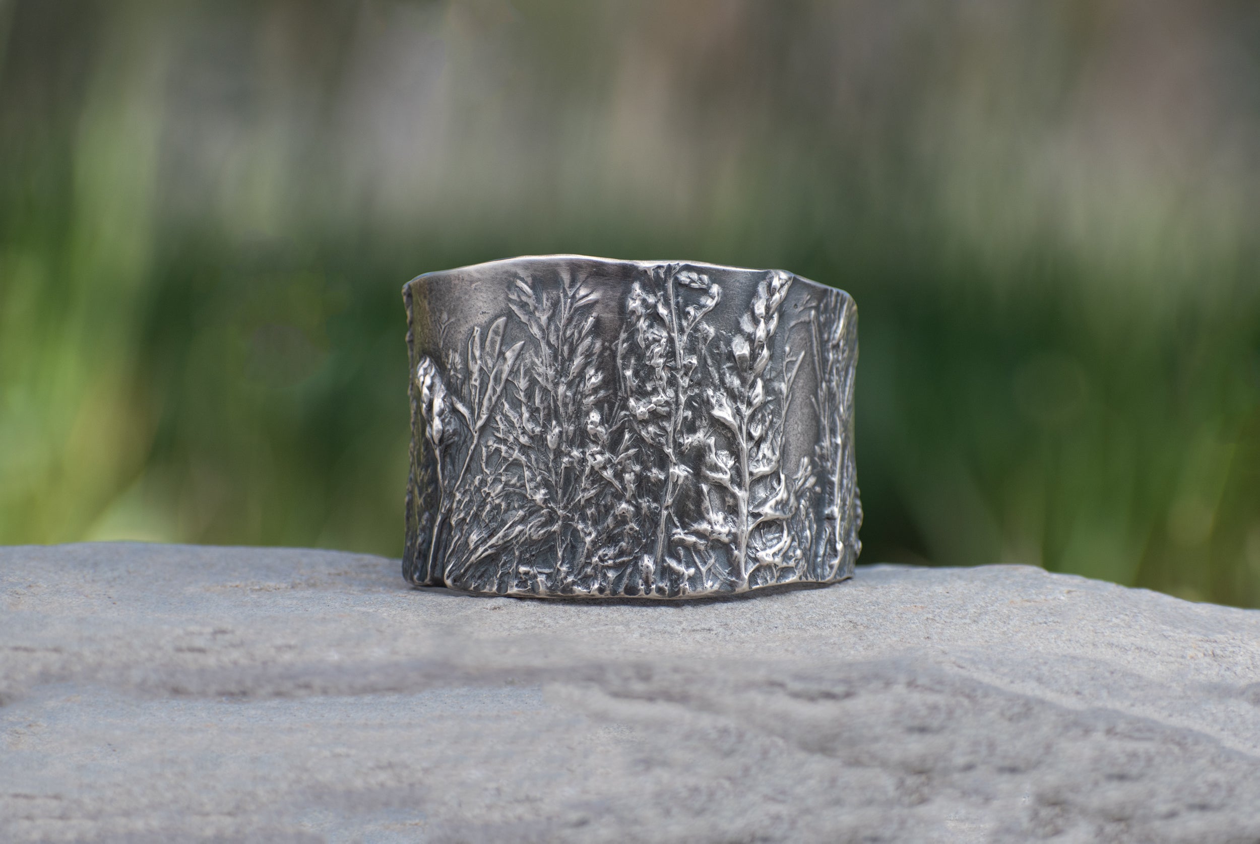 Nature-inspired Wild Meadow Cuff in oxidized sterling silver with layered wildflower and botanical textures from lupine, late-summer sagebrush, goldenrod and wild grasses.