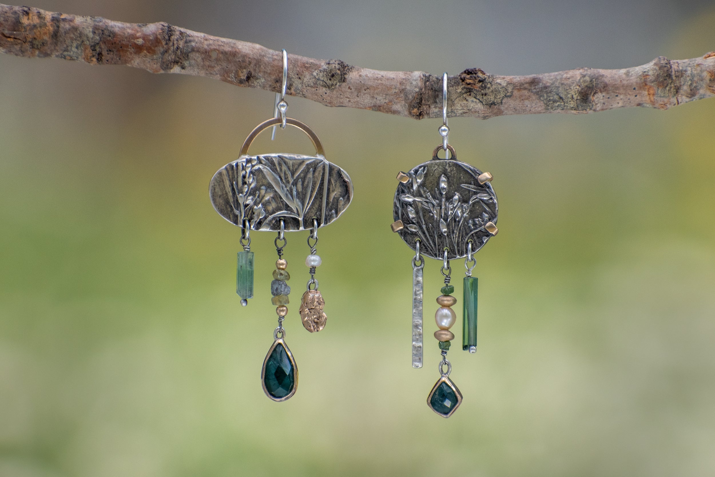 Asymmetrical sterling silver and 14k gold Wild Meadow Earrings with botanical textures and dangling green tourmaline, aquamarine, rough diamond and pearl details.