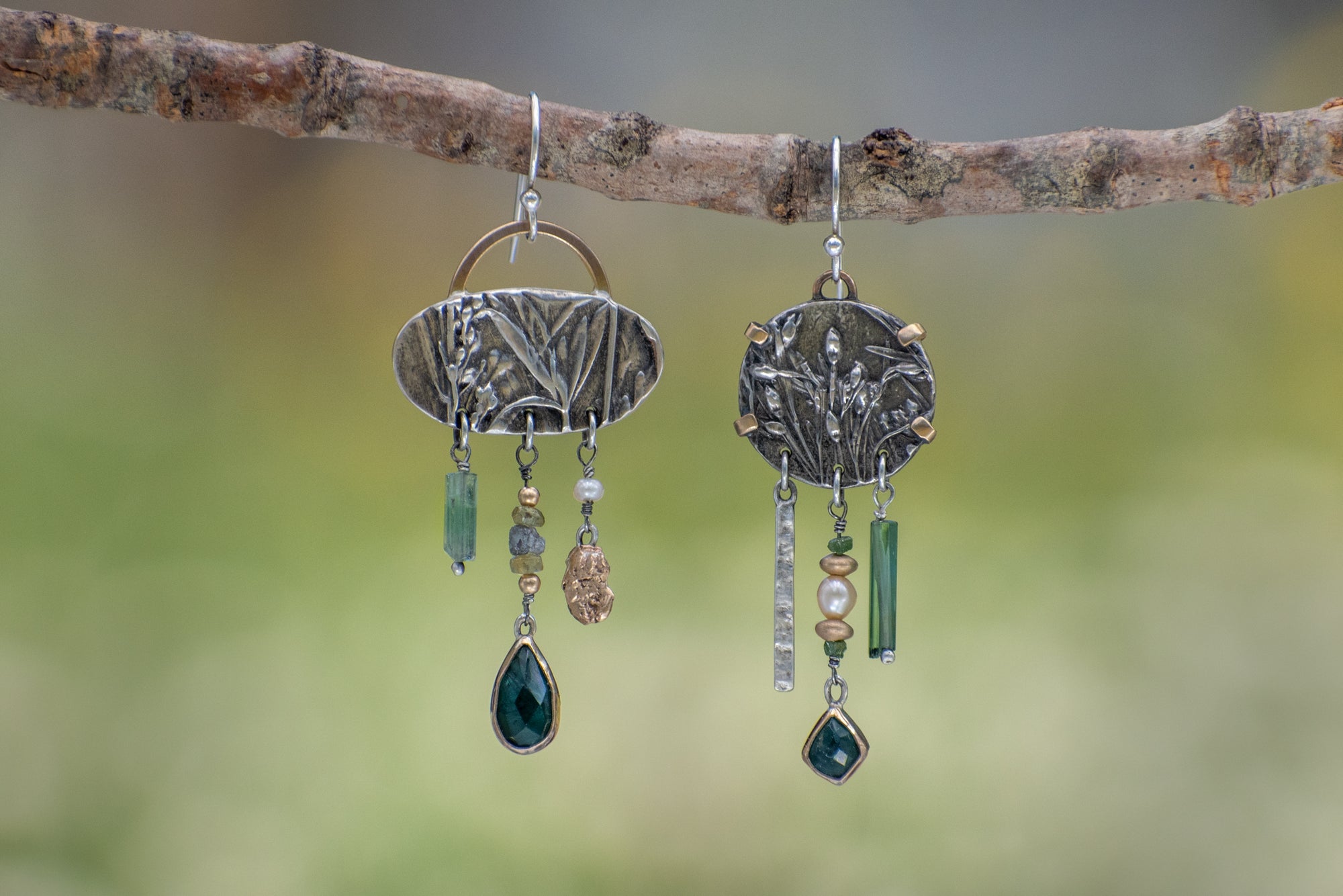 Asymmetrical sterling silver and 14k gold Wild Meadow Earrings with botanical textures and dangling green tourmaline, aquamarine, rough diamond and pearl details.