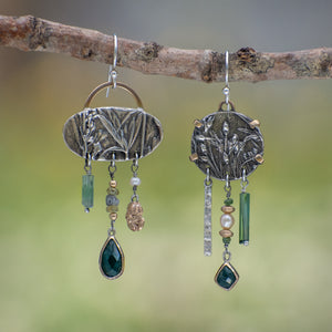 Asymmetrical sterling silver and 14k gold Wild Meadow Earrings with botanical textures and dangling green tourmaline, aquamarine, rough diamond and pearl details.