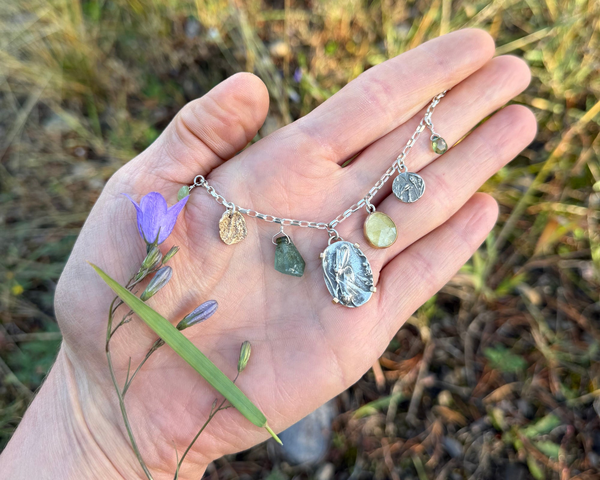 Harebell with wild meadow charm necklace in hand 