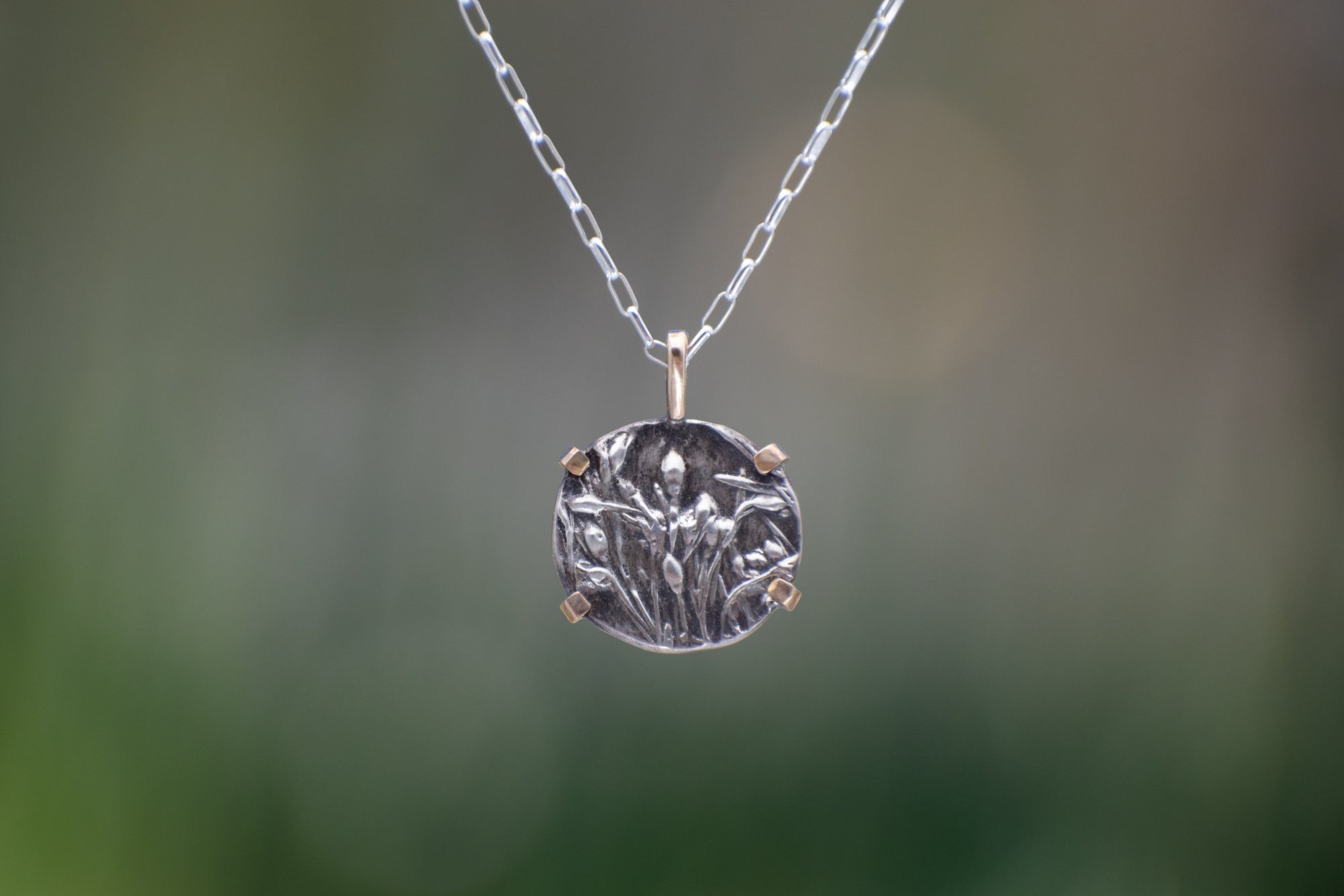 Nature-inspired Round Wild Meadow Necklace in oxidized sterling silver and 14k gold with wildflower and botanical textures from Spreading Groundsmoke stems, leaves and buds.