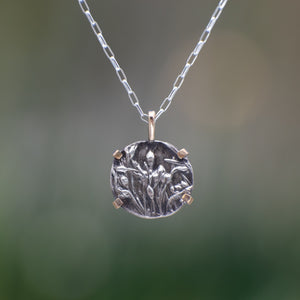 Nature-inspired Round Wild Meadow Necklace in oxidized sterling silver and 14k gold with wildflower and botanical textures from Spreading Groundsmoke stems, leaves and buds.