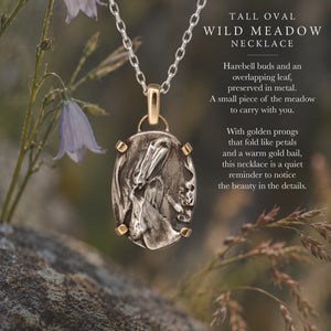 Nature-inspired Oval Wild Meadow Necklace in sterling silver and 14k gold with harebell bud and leaf botanical textures inspired by wildflowers and meadow plants.