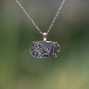 Nature-inspired Horizontal Wild Meadow Necklace in oxidized sterling silver and 14k gold with wildflower and botanical textures from lupine leaves and late-summer sagebrush buds.