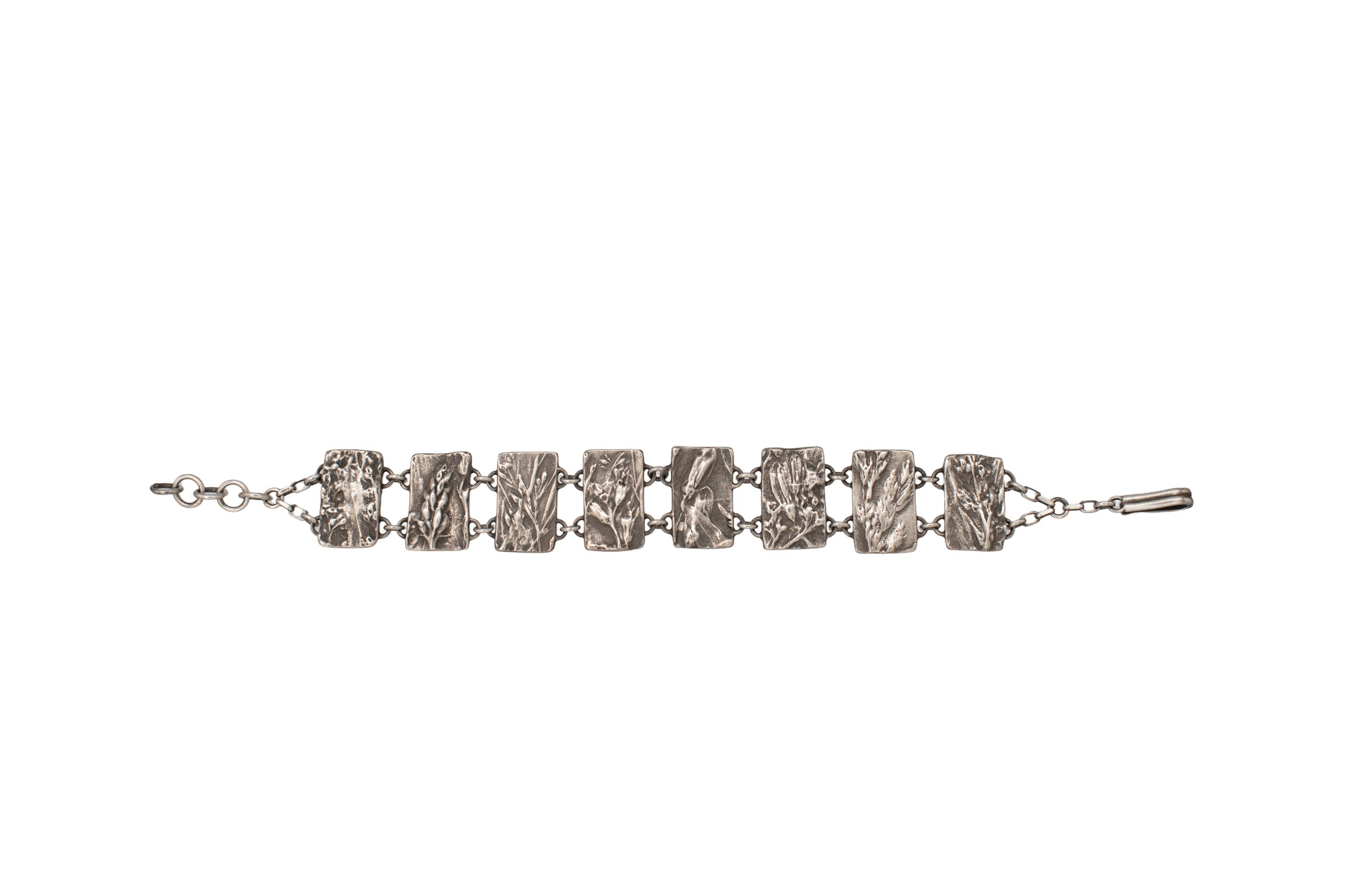 Nature-inspired Wild Meadow Bracelet in oxidized sterling silver with linked botanical panels featuring layered wildflower textures from lupine, sagebrush, goldenrod and wild grasses.