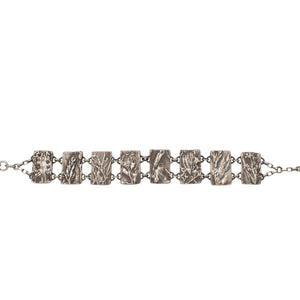Nature-inspired Wild Meadow Bracelet in oxidized sterling silver with linked botanical panels featuring layered wildflower textures from lupine, sagebrush, goldenrod and wild grasses.