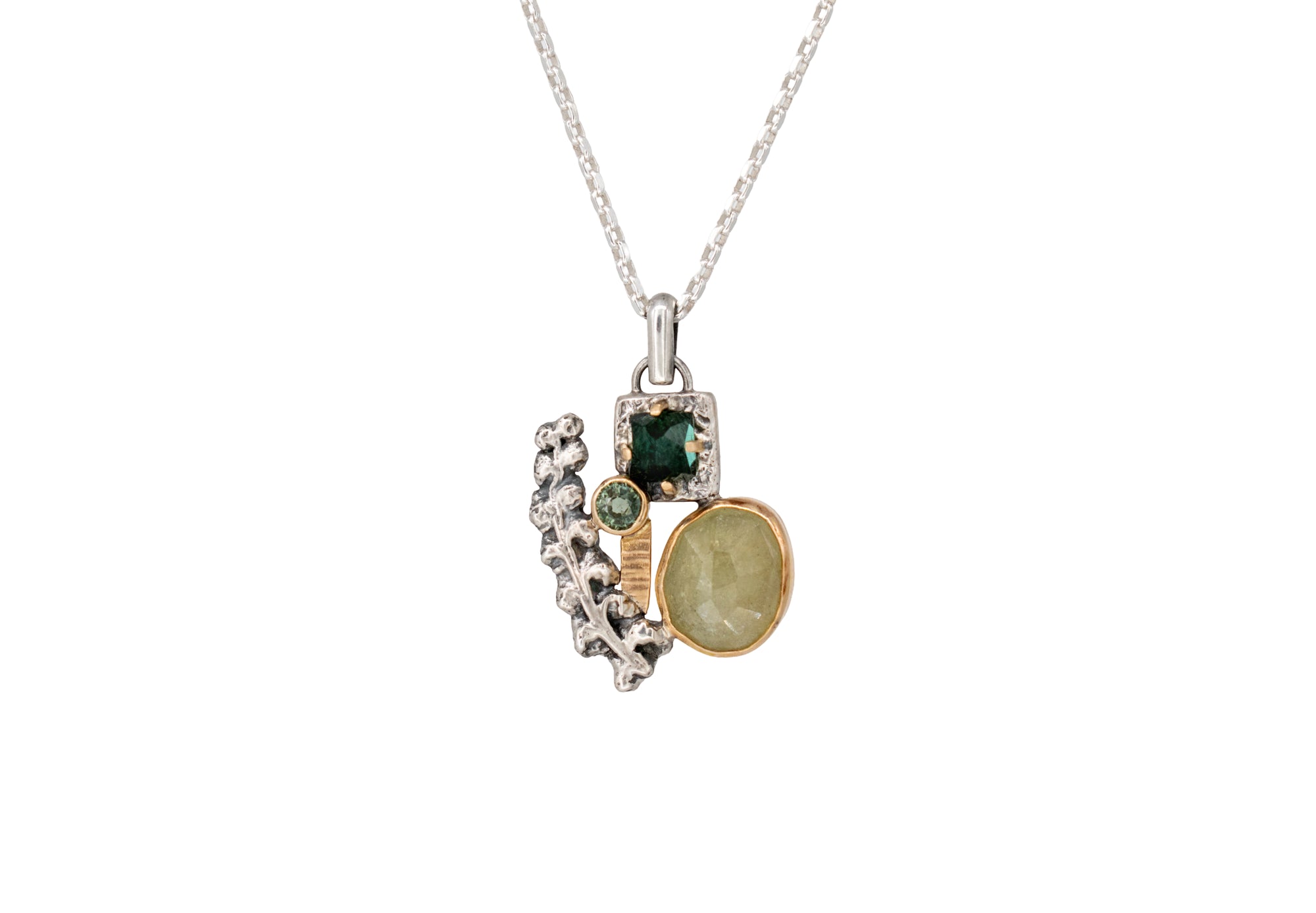 Nature-inspired Wild Meadow Cluster Necklace in sterling silver and 14k gold with sensitive fern botanical texture and two green sapphire gemstones.