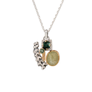 Nature-inspired Wild Meadow Cluster Necklace in sterling silver and 14k gold with sensitive fern botanical texture and two green sapphire gemstones.