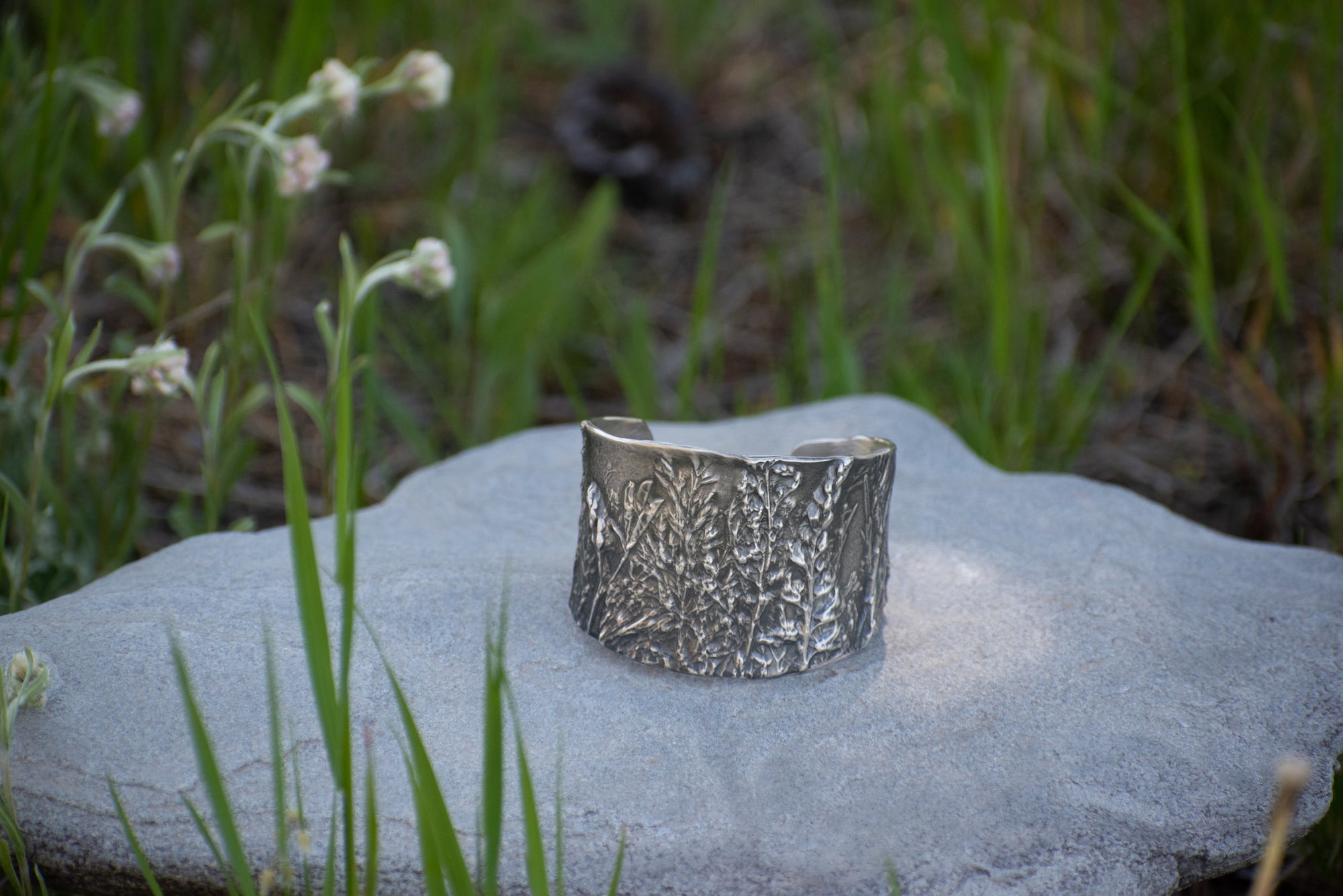 Nature-inspired Wild Meadow Cuff in oxidized sterling silver with layered wildflower and botanical textures from lupine, late-summer sagebrush, goldenrod and wild grasses.