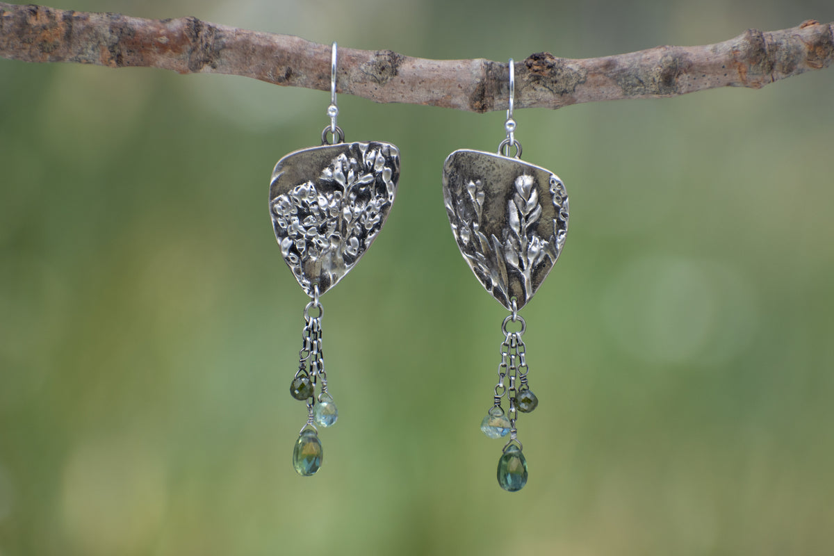 Wild Meadow Triangle Earrings in sterling silver with sagebrush, goldenrod, lupine and wild grass botanical textures, dangling silver chains and green diamond, kyanite and green garnet gemstones.