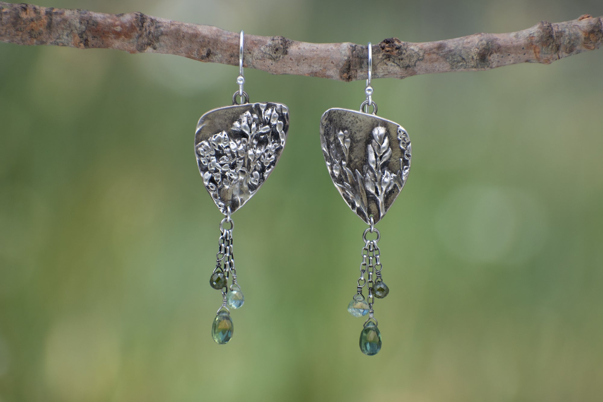 Wild Meadow Triangle Earrings in sterling silver with sagebrush, goldenrod, lupine and wild grass botanical textures, dangling silver chains and green diamond, kyanite and green garnet gemstones.