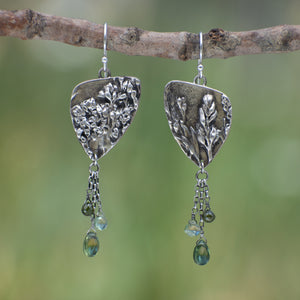Wild Meadow Triangle Earrings in sterling silver with sagebrush, goldenrod, lupine and wild grass botanical textures, dangling silver chains and green diamond, kyanite and green garnet gemstones.