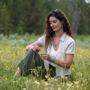 Model wearing Nature-inspired Wild Meadow Charm Necklace in sterling silver and 14k gold with wildflower botanical textures, green sapphire, tourmaline, kyanite and green garnet gemstones.
