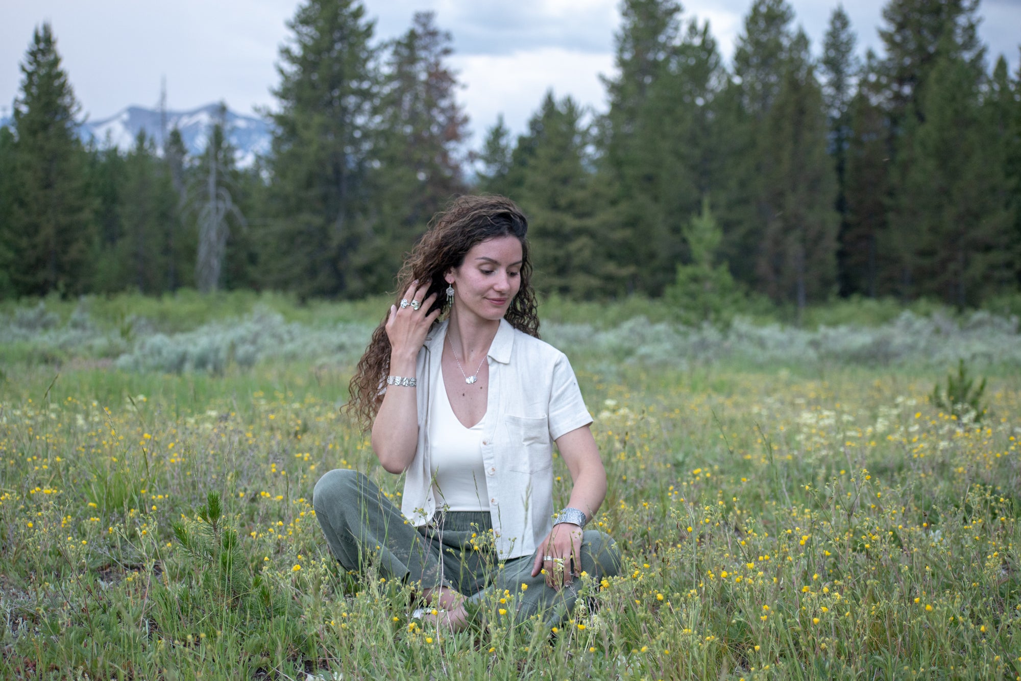 model wearing Nature-inspired Wild Meadow Bracelet in oxidized sterling silver with linked botanical panels featuring layered wildflower textures from lupine, sagebrush, goldenrod and wild grasses.