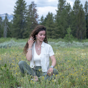 model wearing Nature-inspired Wild Meadow Bracelet in oxidized sterling silver with linked botanical panels featuring layered wildflower textures from lupine, sagebrush, goldenrod and wild grasses.