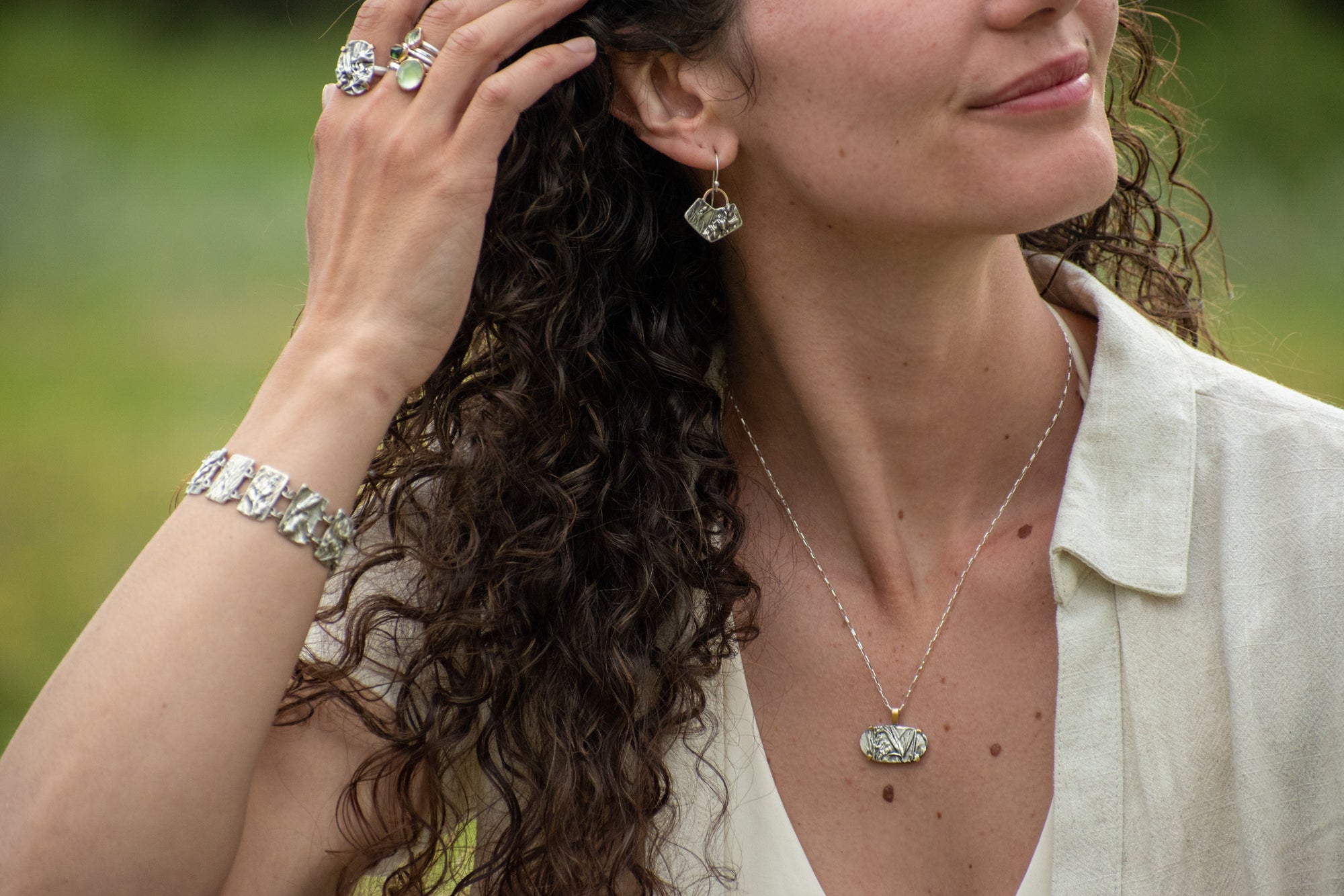 model waring Nature-inspired Oval Wild Meadow Ring in oxidized sterling silver and 14k gold with wildflower and botanical textures from harebell buds and goldenrod.