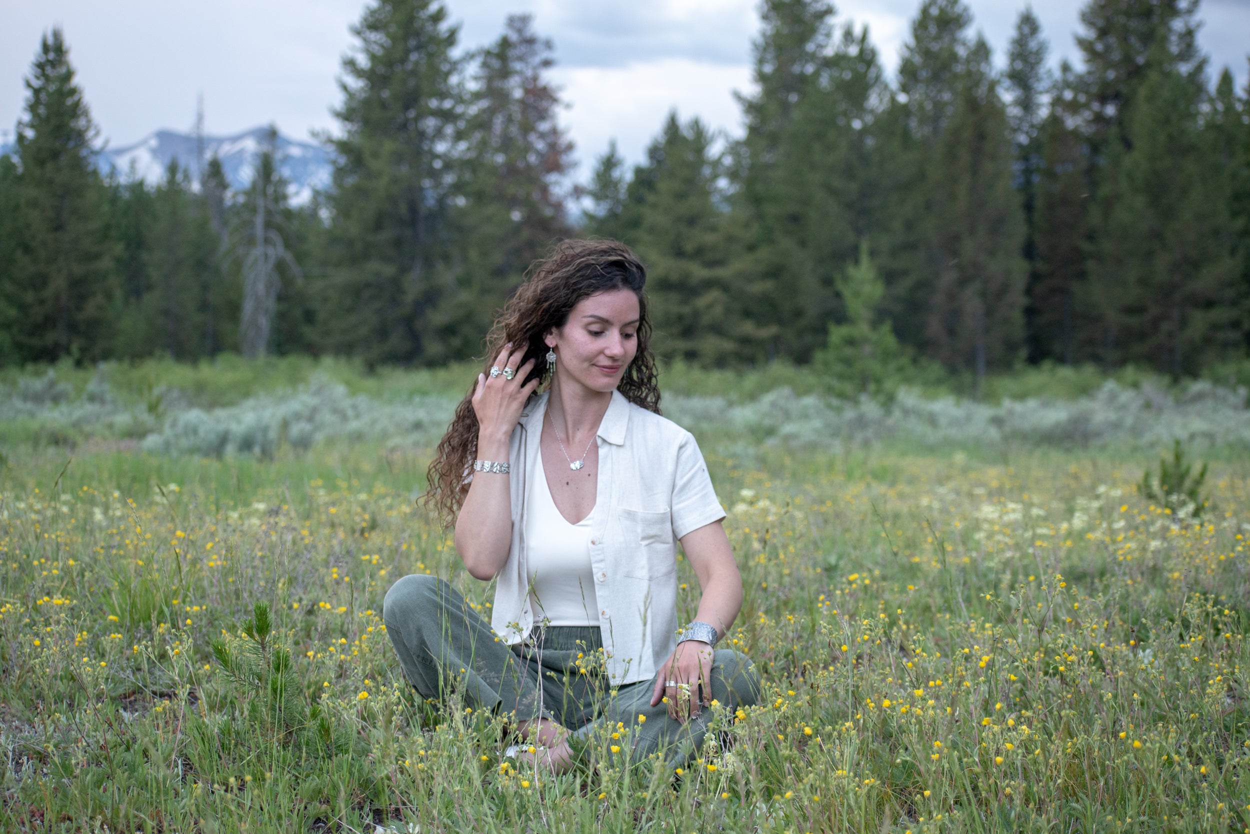 model wearing Nature-inspired Wild Meadow Necklace in oxidized sterling silver with layered wildflower and botanical textures from harebell buds, goldenrod and overlapping leaves.