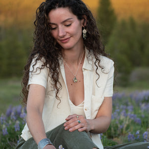model wearing Nature-inspired Wild Meadow Ring Band in oxidized sterling silver with layered wildflower and botanical textures from budding sage, sage leaves and goldenrod.