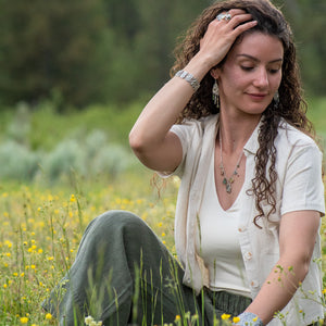 model wearing Nature-inspired Wild Meadow Bracelet in oxidized sterling silver with linked botanical panels featuring layered wildflower textures from lupine, sagebrush, goldenrod and wild grasses.