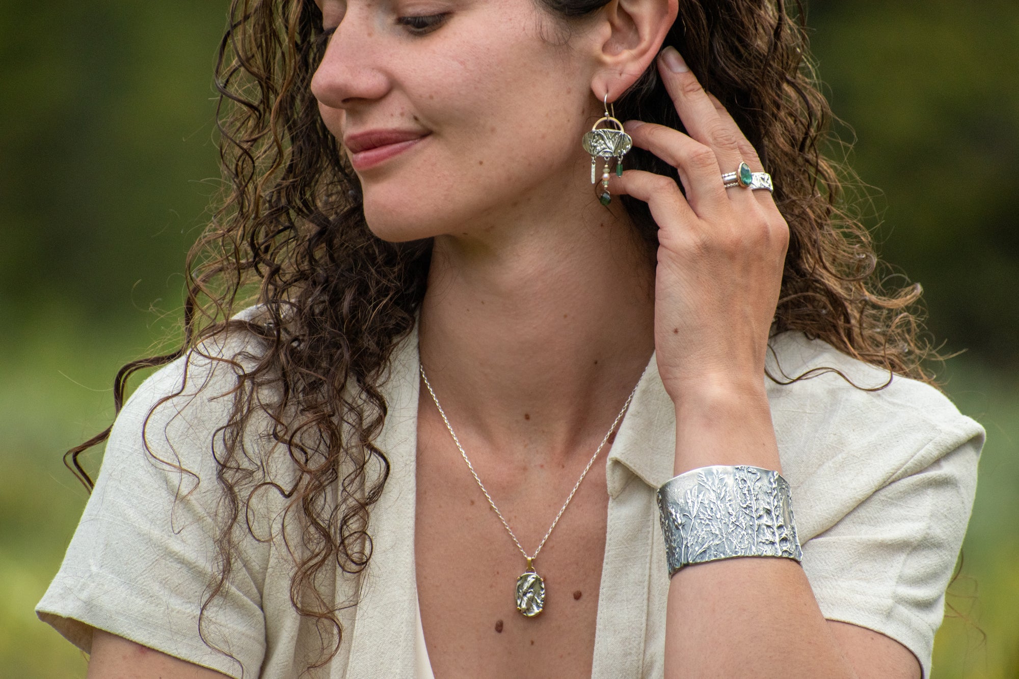 model wearing Nature-inspired Wild Meadow Cuff in oxidized sterling silver with layered wildflower and botanical textures from lupine, late-summer sagebrush, goldenrod and wild grasses.