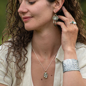 model wearing Nature-inspired Wild Meadow Cuff in oxidized sterling silver with layered wildflower and botanical textures from lupine, late-summer sagebrush, goldenrod and wild grasses.