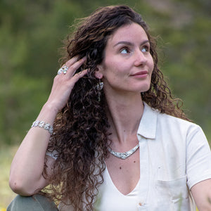 model wearing Nature-inspired Wild Meadow Texture Necklace in sterling silver with layered wildflower and botanical textures from lupine petals, goldenrod, sage leaves and wild grasses.
