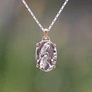 Nature-inspired Oval Wild Meadow Necklace in sterling silver and 14k gold with harebell bud and leaf botanical textures inspired by wildflowers and meadow plants.