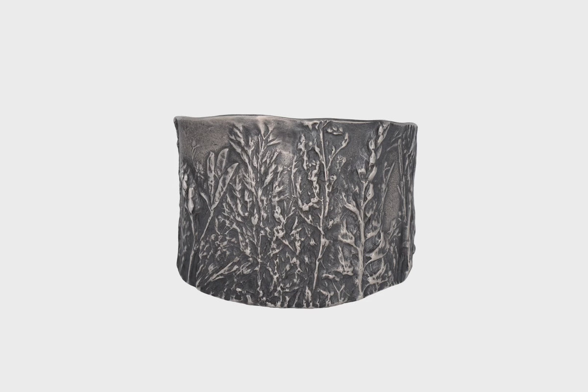 Nature-inspired Wild Meadow Cuff in oxidized sterling silver with layered wildflower and botanical textures from lupine, late-summer sagebrush, goldenrod and wild grasses.