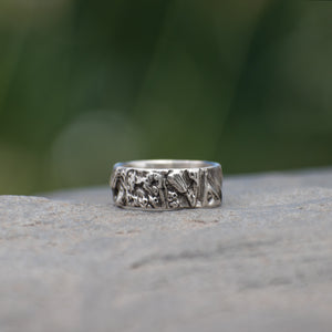 Nature-inspired Wild Meadow Ring Band in oxidized sterling silver with layered wildflower and botanical textures from budding sage, sage leaves and goldenrod.