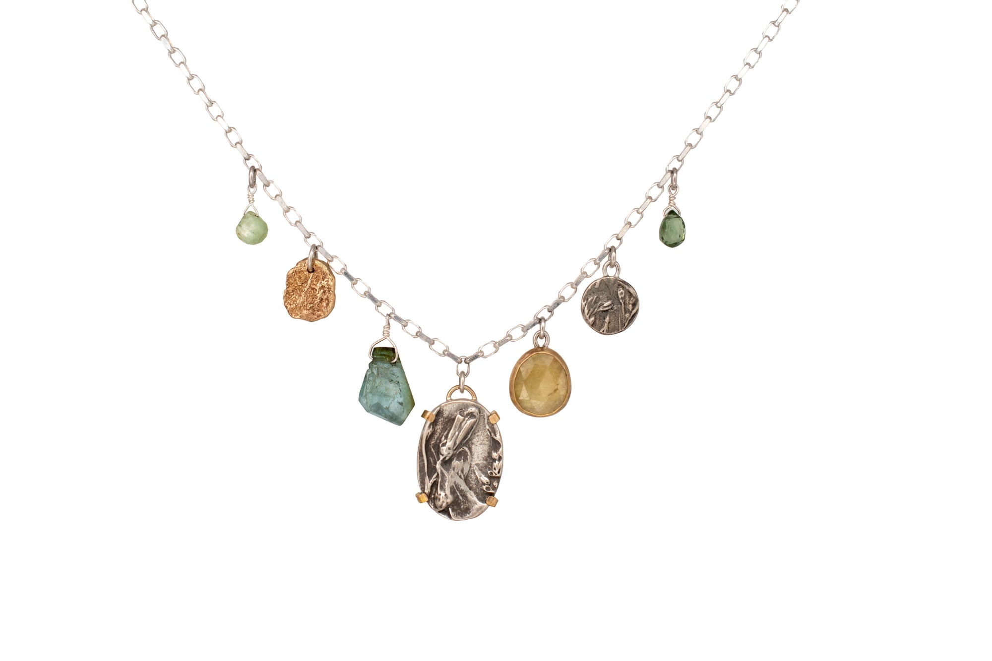Nature-inspired Wild Meadow Charm Necklace in sterling silver and 14k gold with wildflower botanical textures, green sapphire, tourmaline, kyanite and green garnet gemstones.
