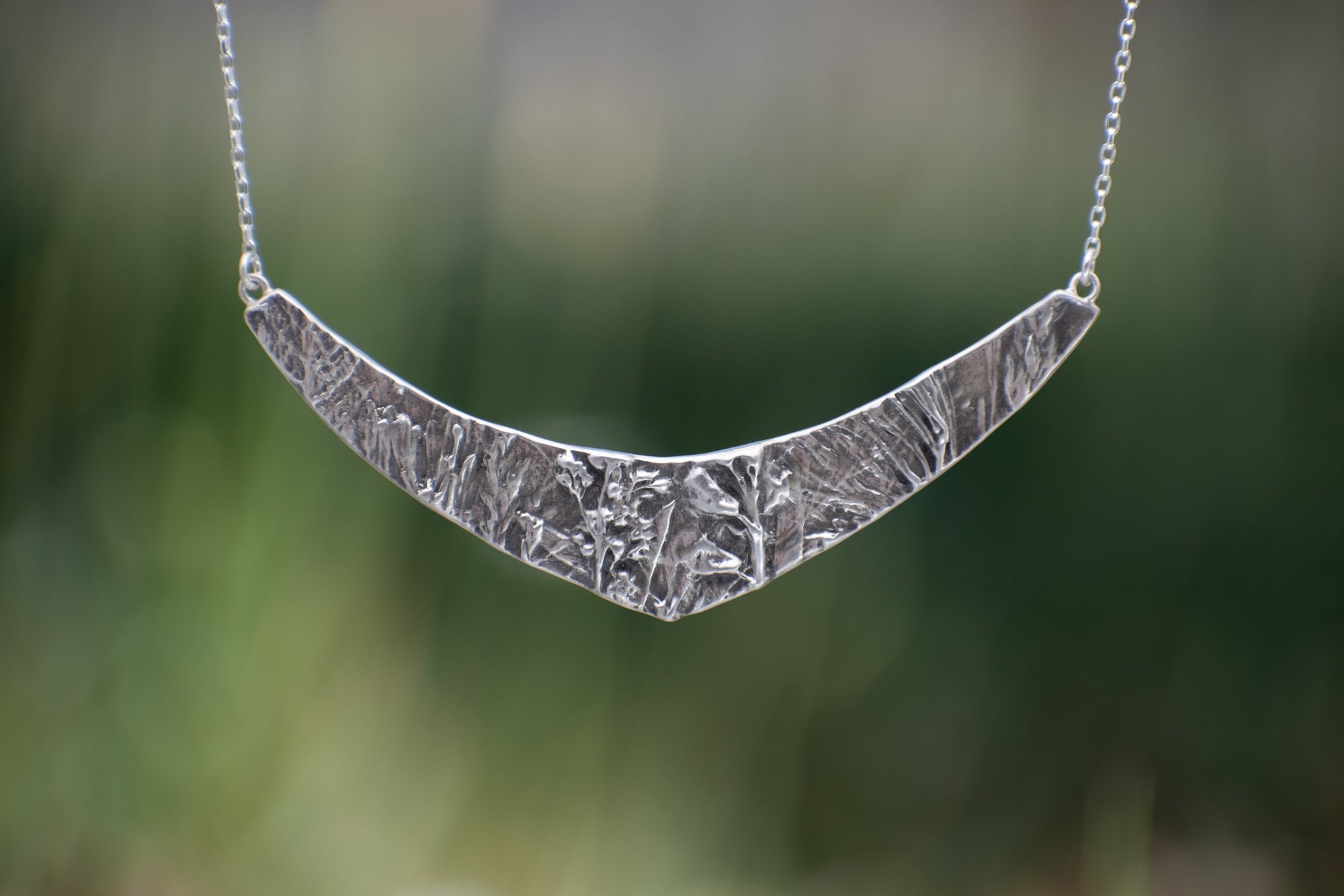 Nature-inspired Wild Meadow Texture Necklace in sterling silver with layered wildflower and botanical textures from lupine petals, goldenrod, sage leaves and wild grasses.
