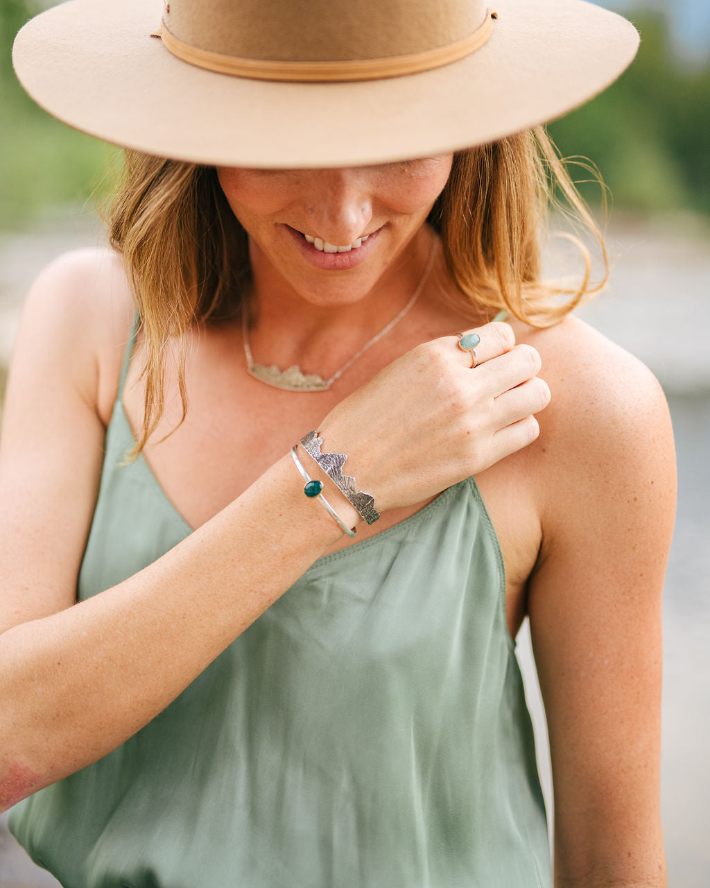 Woman wearing silver mountain cuff bracelet and necklace