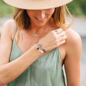 Woman wearing silver mountain cuff bracelet and necklace