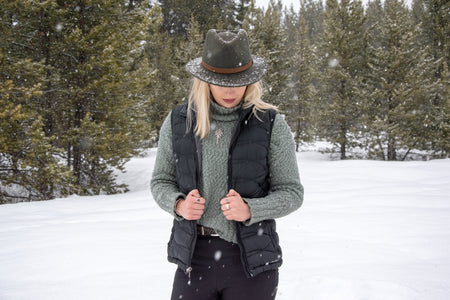 Woman wearing handmade silver and 14k gold botanical jewelry in winter