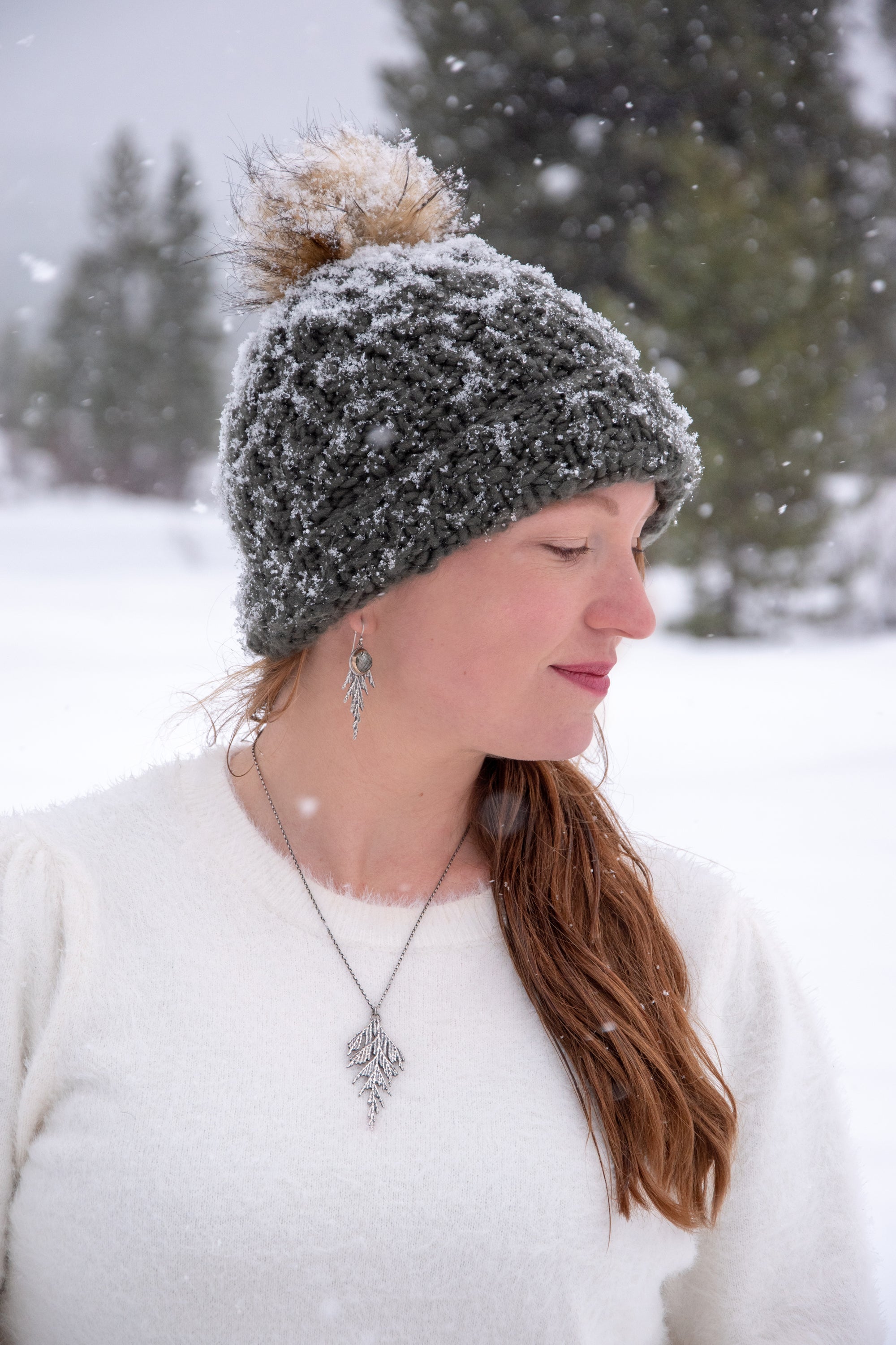 Woman wearing silver and gold cedar jewelry in winter