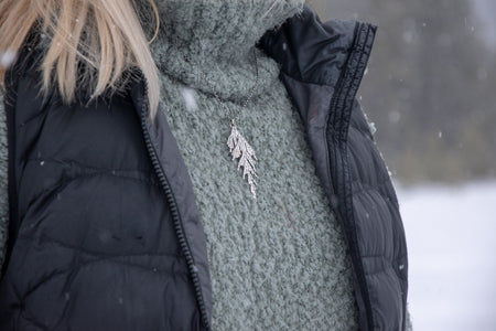 Woman wearing handmade silver cedar necklace in winter