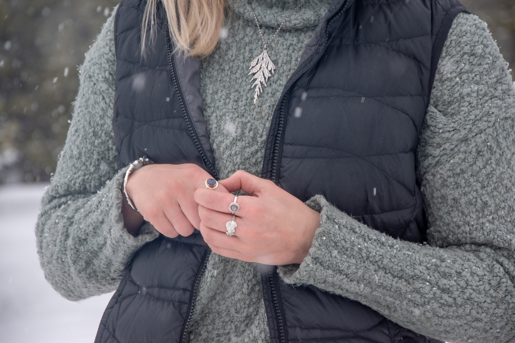 Woman wearing handmade, silver, nature inspired jewelry in winter 
